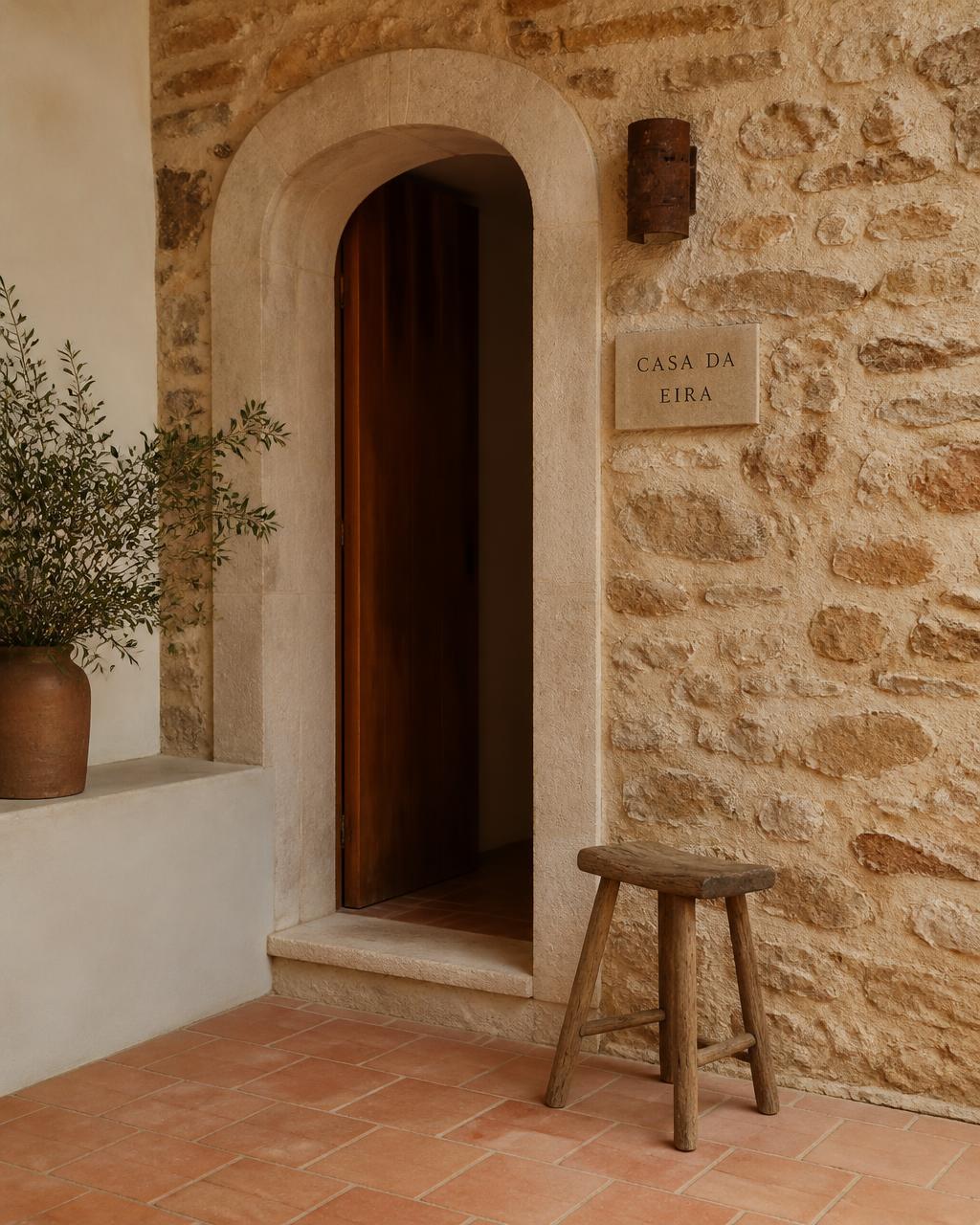 Stone facade with an arched wooden door of a traditional Portuguese house
